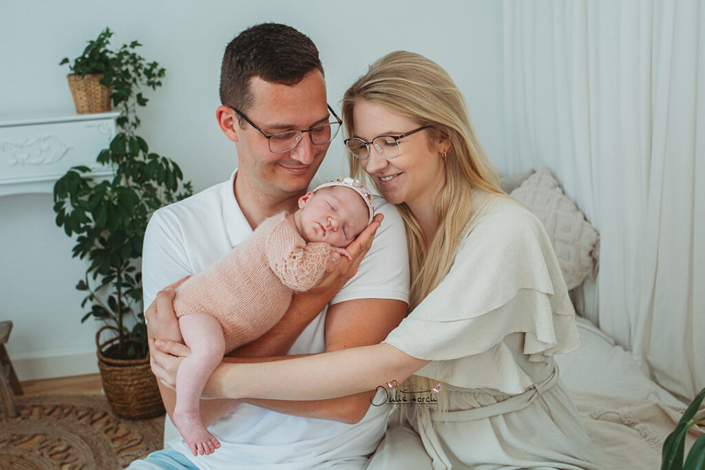 Mama und Papa mit Baby / Neugeborenem im Arm